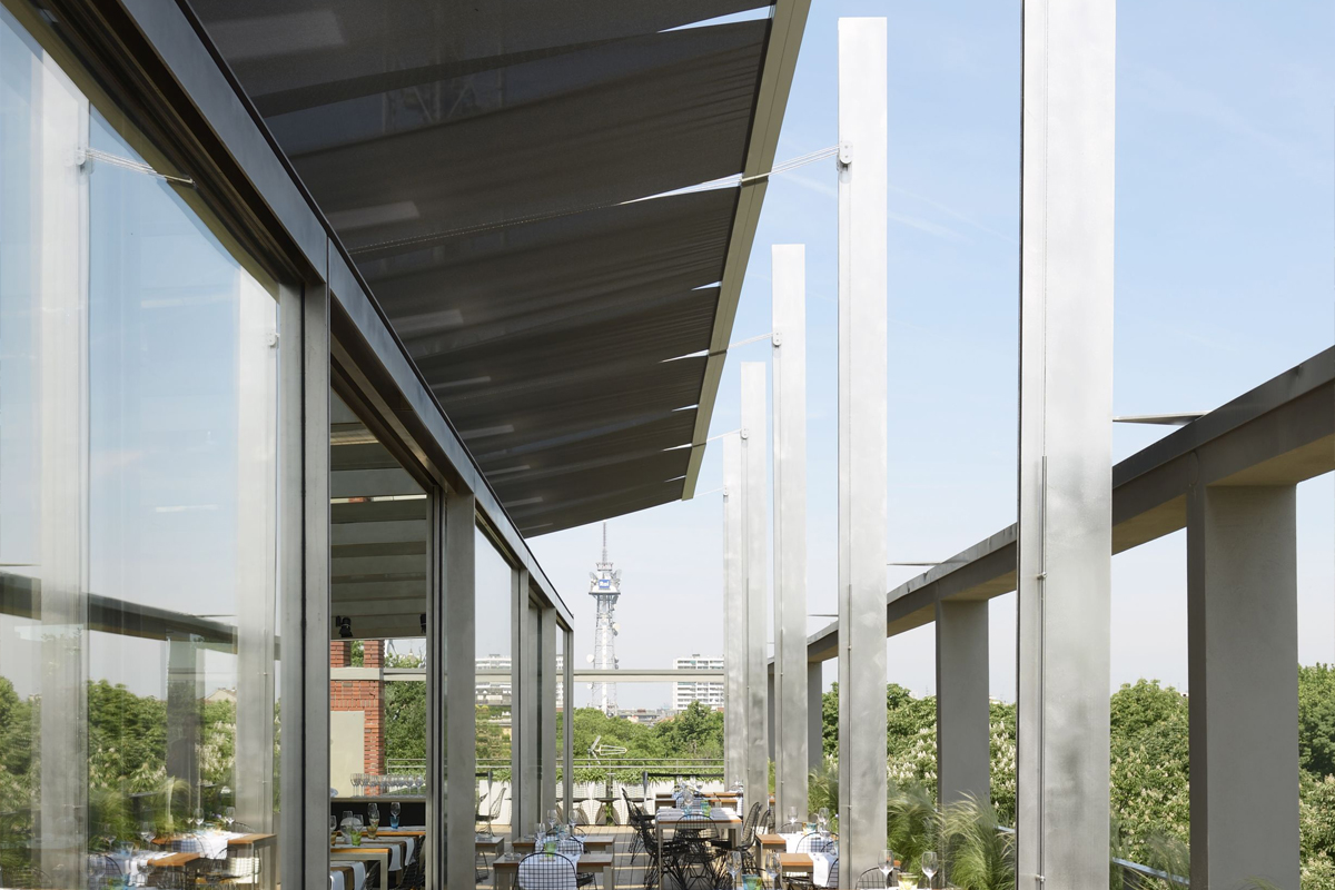 Pathio di un ristorante in cui sono state installate tende da sola che coprono i tavoli